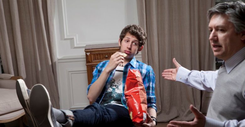 Cresce o número de jovens entre 15 e 29 anos que não estudam nem trabalham A disinterested teenager eating potato chips and being lectured to by his father 780x405 - Cresce o número de jovens entre 15 e 29 anos que não estudam nem trabalham